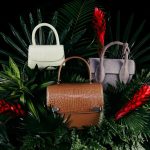 brown leather handbag on green pine tree